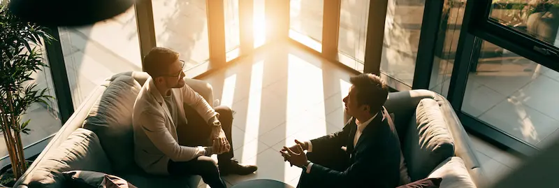 In-person counseling in a professional office, therapist and client speaking face to face, safe and cozy environment, realistic photo style.